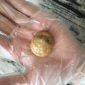 手上沾点干粉，捏起一块面糊，搓成圆球形