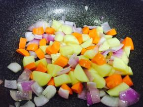 另取一锅，放少许油，加入洋葱炒香，然后加入胡萝卜块和土豆块