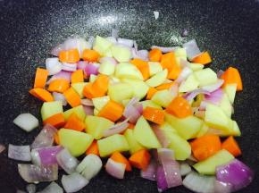 另取一锅，放少许油，加入洋葱炒香，然后加入胡萝卜块和土豆块