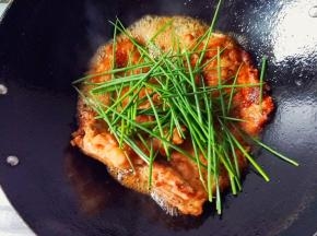 再倒入煎好的大排，倒入适量的料酒，生抽，清水，再把香葱全部放入锅中