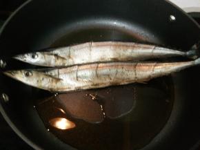 放入秋刀鱼中火煎至一面金黄后翻面，另一面也煎至金黄。