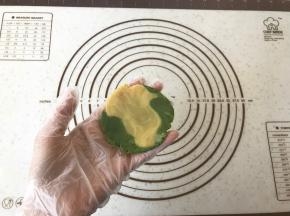 包月饼，这里简单介绍两种方法：
如果只是两种颜色随意混合，那么挑选两块不同颜色的饼皮，揉合在一起（不要过度揉合），压扁。