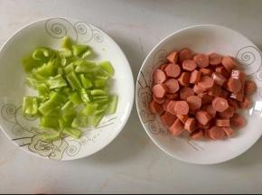 火腿肠切成薄片，辣椒洗净切片