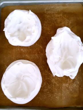 烤盘铺油纸，将蛋白装入裱花袋，挤出三份圆形，用勺背在中间转圈抹一下，抹出碗的形状即可，烤箱预热130度烤60分钟