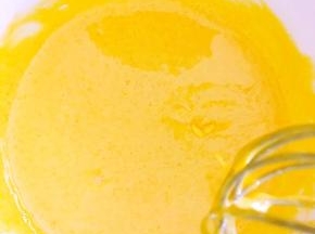 将热牛奶一点点加入到蛋黄糊中，并不停搅拌