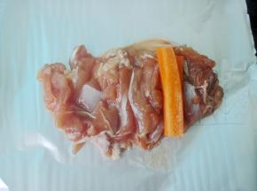 取出腌好的鸡腿，摊开放在锡纸上，放上切好的胡萝卜条