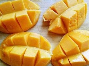 芒果洗干净，从中间切开，再果肉上划几刀，如图。