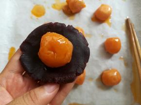 取一个豆沙馅球按扁包上蛋黄