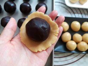 取一个饼皮按扁，放上月饼馅球