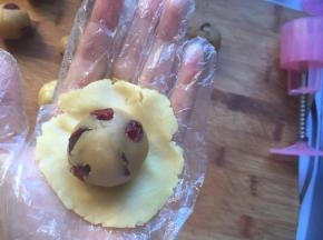 将饼皮压扁，绿豆馅放在饼皮上