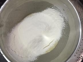 将低粉，泡打粉，盐混合过筛加入鸡蛋液中，搅拌至没有颗粒。