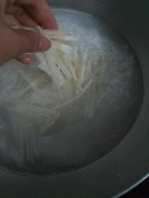 煮到半熟时，将切好的梨跟冰糖放入粥里一起炖