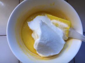 分三分之一的蛋白到蛋黄糊中，用搅拌刀从下往上搅拌均匀