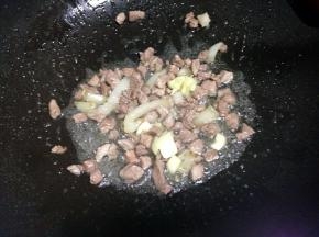 锅里倒入油，加入切好的肉翻炒变色再放蒜炒香盛出。