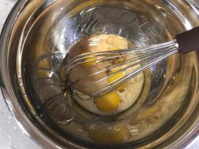 蛋黄里倒入奶茶液和玉米油，用手抽搅拌均匀，充分乳化。红茶碎一起加入，不用滤出。