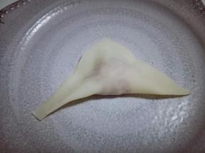 将馄饨皮赶角对折，如图。