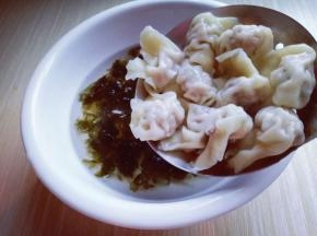 煮熟的小馄饨捞出放入紫菜虾皮的器具中。