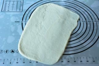 取出面团排气，将白色面团擀成一张大面皮。