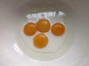 鸡蛋分开蛋清和蛋黄，把蛋黄和玉米油牛奶放在一个大碗里拌匀。