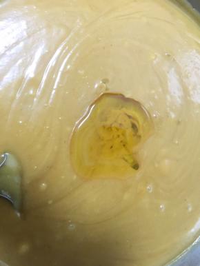 糖完全融化并与莲子泥吸收后加入一大勺花生油，不断地翻炒，待油与莲子泥完全吸收后再加入下一次的油，直至全部的油加完。中途莲子泥会冒泡沸腾，转中小火