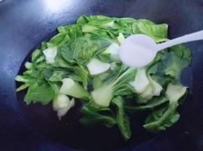 将青菜焯水，锅中加入水大火烧开，加入洗干净的青菜，加入一勺盐，滴几滴食用油，烧开即可。