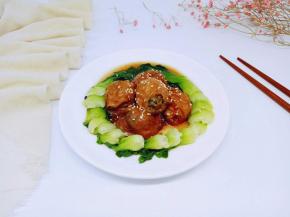 装盘撒上熟白芝麻，将焯过水的青菜，摆放在盘子里，将面筋塞肉围一圈。