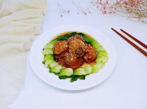 装盘撒上熟白芝麻，将焯过水的青菜，摆放在盘子里，将面筋塞肉围一圈。