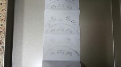 1．在纸上画好龙猫的图案，翻过来有笔记的一面朝向烤盘。