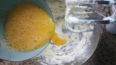 4．把蛋液分多次，加入打发的黄油中，每次加入融合后，再加入下一次。