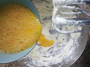 4．把蛋液分多次，加入打发的黄油中，每次加入融合后，再加入下一次。