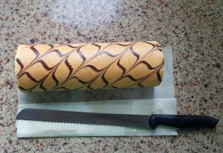 9．出炉后晾至温热，将果酱抹在蛋糕卷的反面，用擀面杖辅助卷起，OK了。