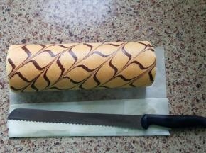 9．出炉后晾至温热，将果酱抹在蛋糕卷的反面，用擀面杖辅助卷起，OK了。