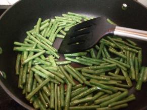锅里加适量油烧热后倒入豆角小火煸炒