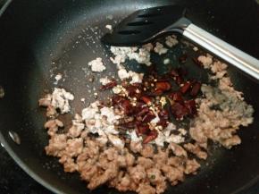 加入红椒和花椒炒出香味。