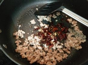 加入红椒和花椒炒出香味。