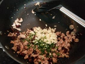 加入葱花和蒜末炒出香味。