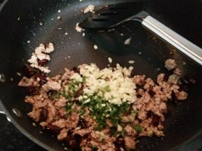 加入葱花和蒜末炒出香味。