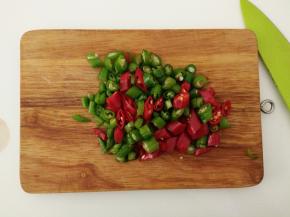 去蒂后把青红辣椒切成丁。