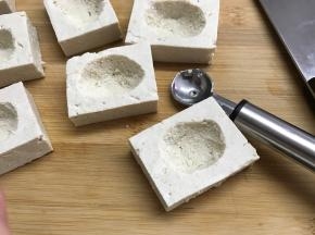用勺子将每块豆腐中间挖个小坑。