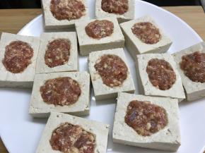 在每块豆腐挖掉的地方放入肉馅。