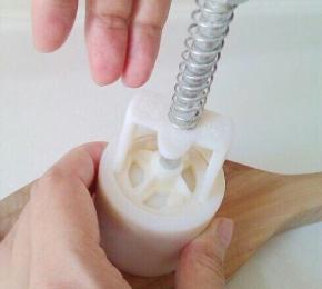 10、月饼胚稍搓成柱型，放入模具，一手扶模具下端，另一手果断用力向下压，然后提起模具，向下轻压，月饼出。 