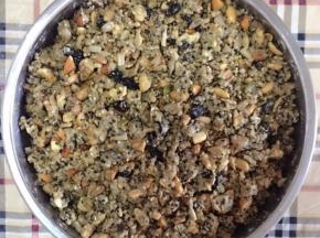 2、坚果全部放入容器中，放入蜂蜜、面粉（食材中糯米粉和中筋面粉分开炒熟）、油（熟）、水搅拌均匀。