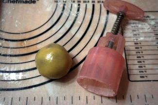 将面团压开后包裹好馅料，滚圆，拍粉，放入模具中。