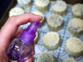 在月饼表面喷洒少许清水，放入预热好的烤箱中层，上下火210度烘烤8分钟定型。