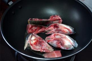 这个时候将鱼头煎香。锅里下油，加入鱼头块，中火，慢慢煎香。