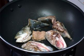 将鱼头翻转，继续煎香另一面。