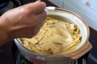 这个时候，往腐竹里加入2勺子食盐，2勺子砂糖，搅拌均匀。