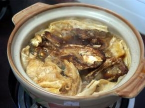 将鱼头转移到砂锅里，铺在腐竹上。
