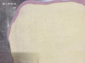 铺上同样擀成长方形片状的白色面团，再用擀面杖压一遍，使两种面团完全贴合
