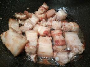 等冰糖融化，加煎好的五花肉翻炒，